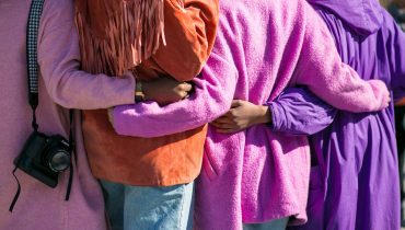 four person holding each others waist at daytime