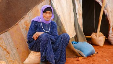 A woman sitting in front of a tent