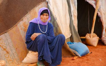 A woman sitting in front of a tent