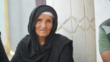 a woman in a black shawl sitting next to a man